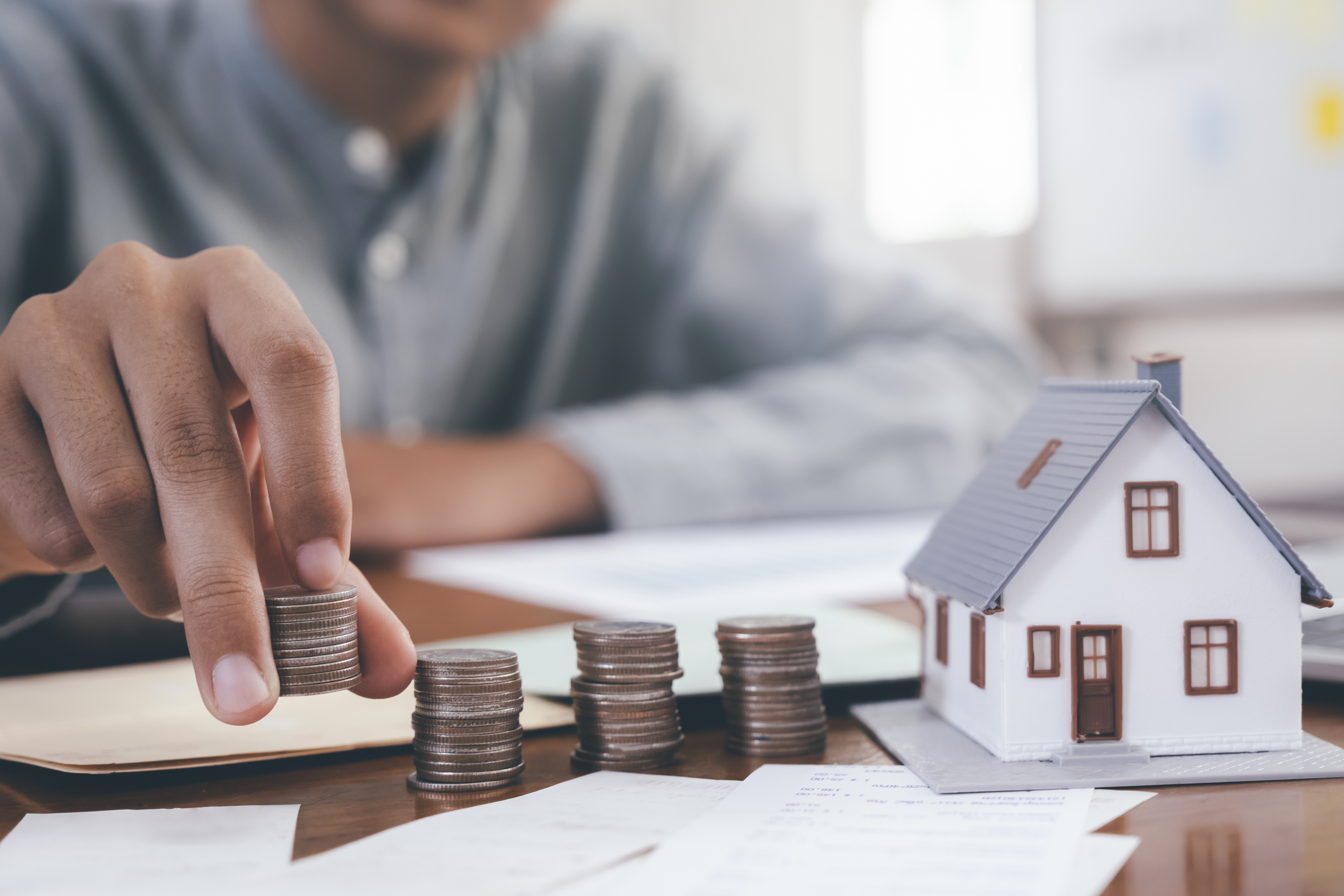 Close up male hand calculate the money for investment in property and mortgage. Finance and saving money for investment.